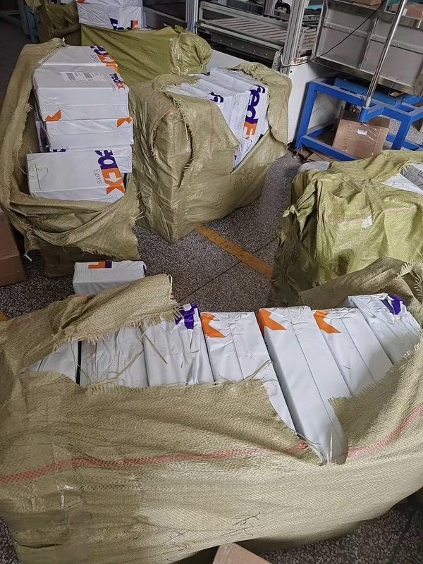 Outbound order packages wrapped in protective sacks ready for international courier pickup